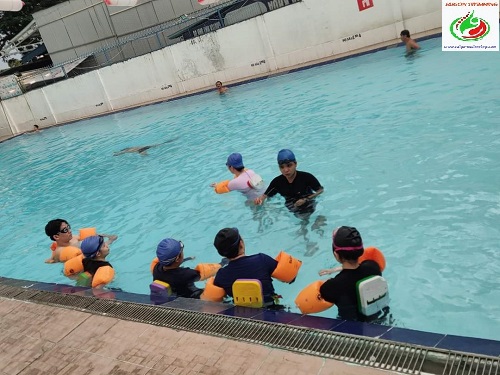 Giáo viên trực tiếp xuống nước hướng dẫn kỹ thuật bơi cho học viên ở lớp học bơi Quận Tân Bình